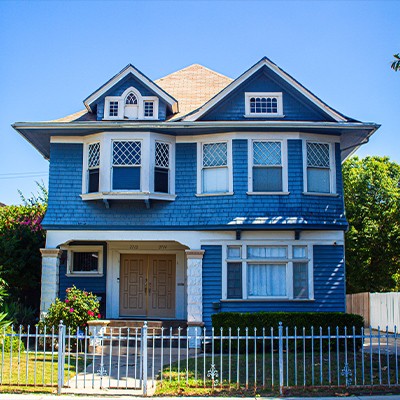 A blue and white victorian home in the bustling adams-normandie area of west adams in los angeles