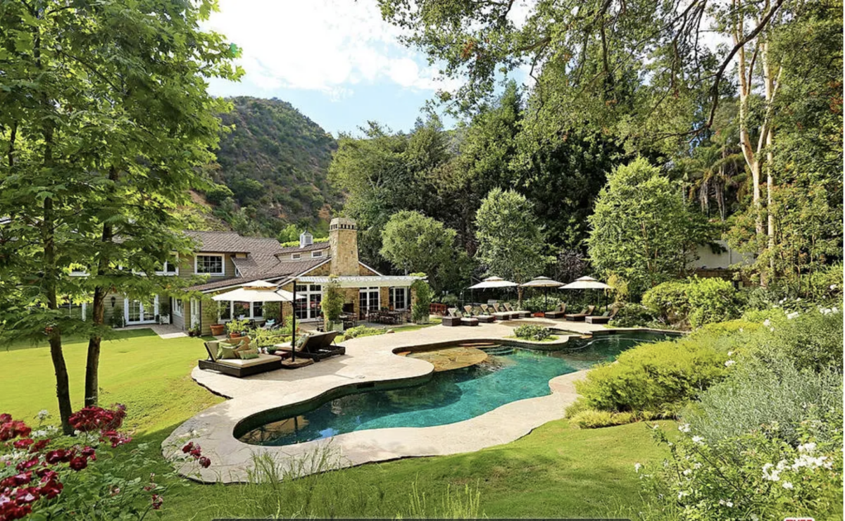 Niche Communities 4 a pool and a house with trees and a hill in the background