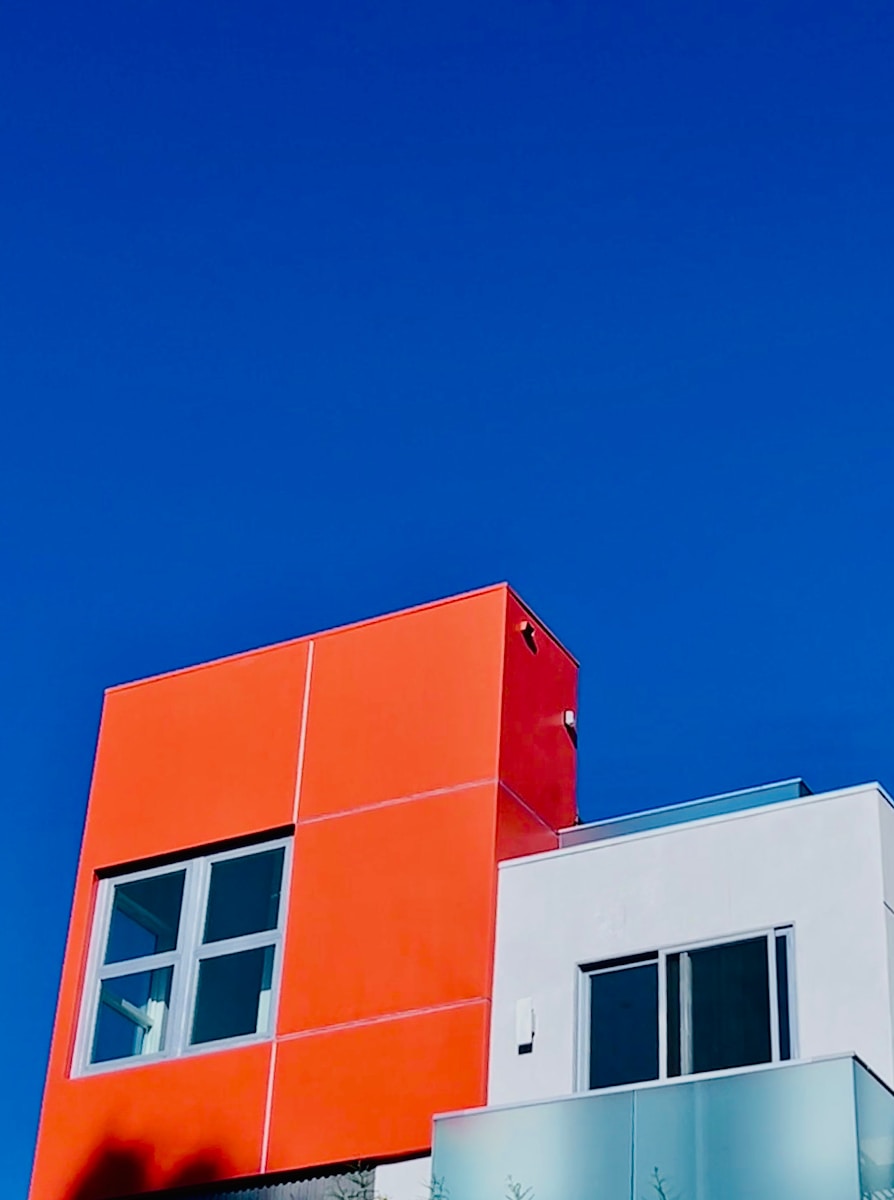 an orange and white building against a blue sky