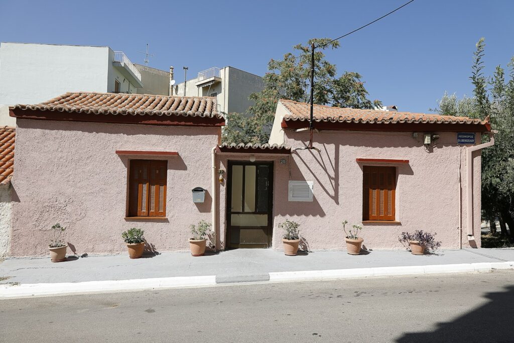 a pink building with two windows and a door