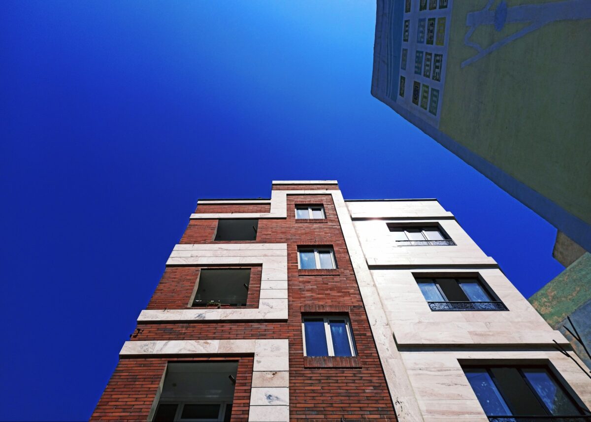 looking up at a tall brick building with windows