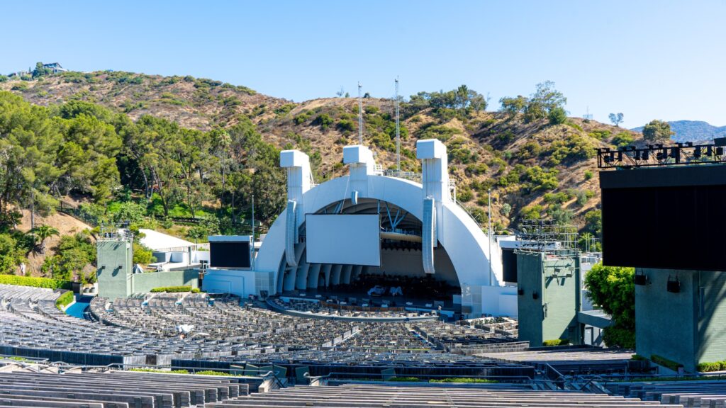 A view of a building from a distance with mountains in the background