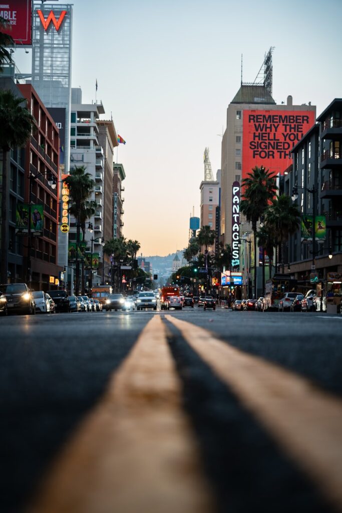 A city street with tall buildings and palm trees