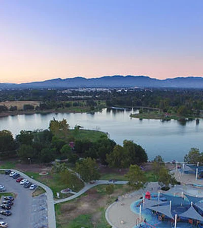 Lake Balboa a lake with a parking lot and a park with trees and a mountain in the background