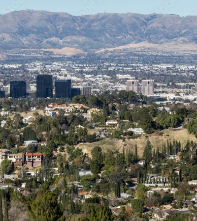 a city with trees and mountains in the background