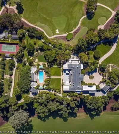 aerial view of a large house with a pool and golf course