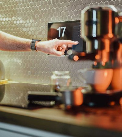 smart homes for sale a person pressing a button on a coffee machine