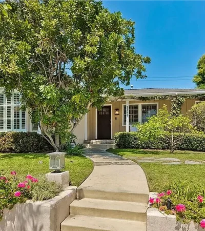 a house with a walkway and a tree