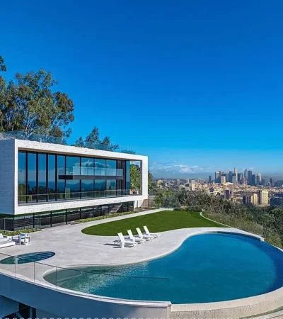 a pool with a large building and a city in the background