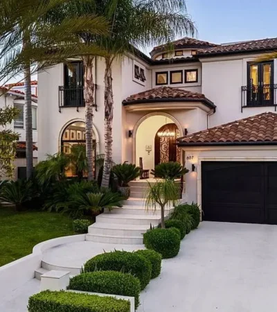 a house with a driveway and palm trees