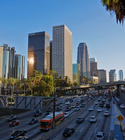 downtown los angeles a traffic on a freeway with a city skyline in the background