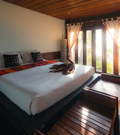 bungalow white bed linen near brown window curtain