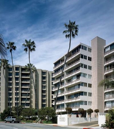 a building with palm trees and a parking lot