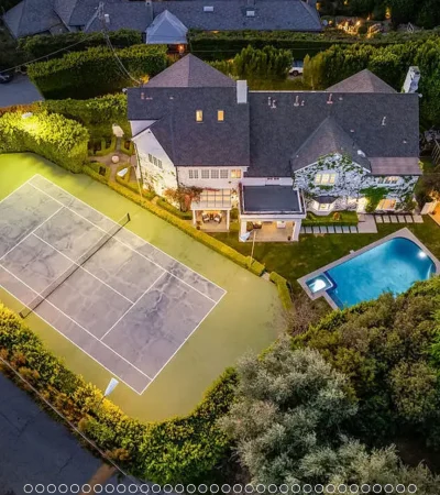 a tennis court and pool in a large house