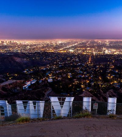 hollywood a sign on a hill with a city in the background