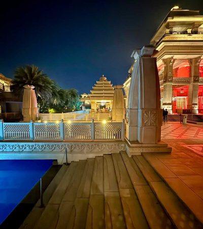 ultra luxury homes for sale a night view of a building with a pool in front of it