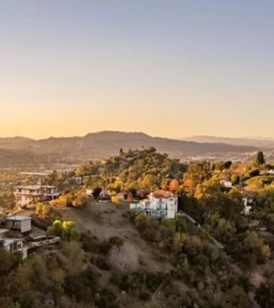 a landscape with trees and buildings on a hill
