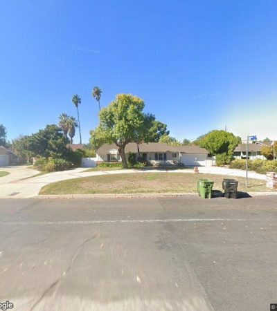 Street view of Oak Park neighborhood in Los Angeles showing tree-lined residential street with luxury homes