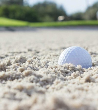 white golf ball on brown sand during daytime