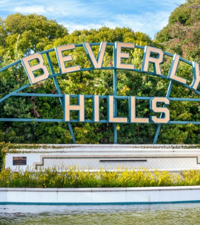 luxury homes for sale in beverly hills a sign that says beverly hills in front of a body of water