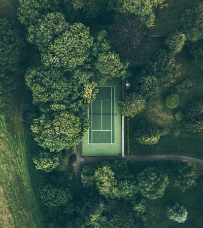 house with tennis court for sale aerial photo of tennis court surrounded with trees