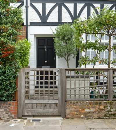 a white house with a black door and gate
