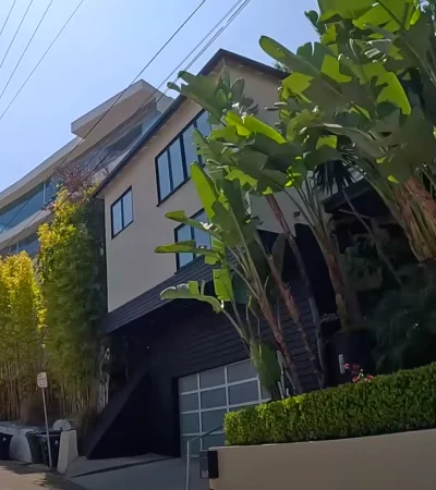 a building with trees and bushes on the side of it