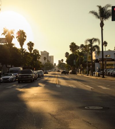 the sun is setting over a city street
