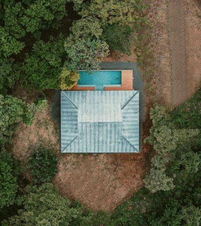 blue and white wooden house surrounded by green trees